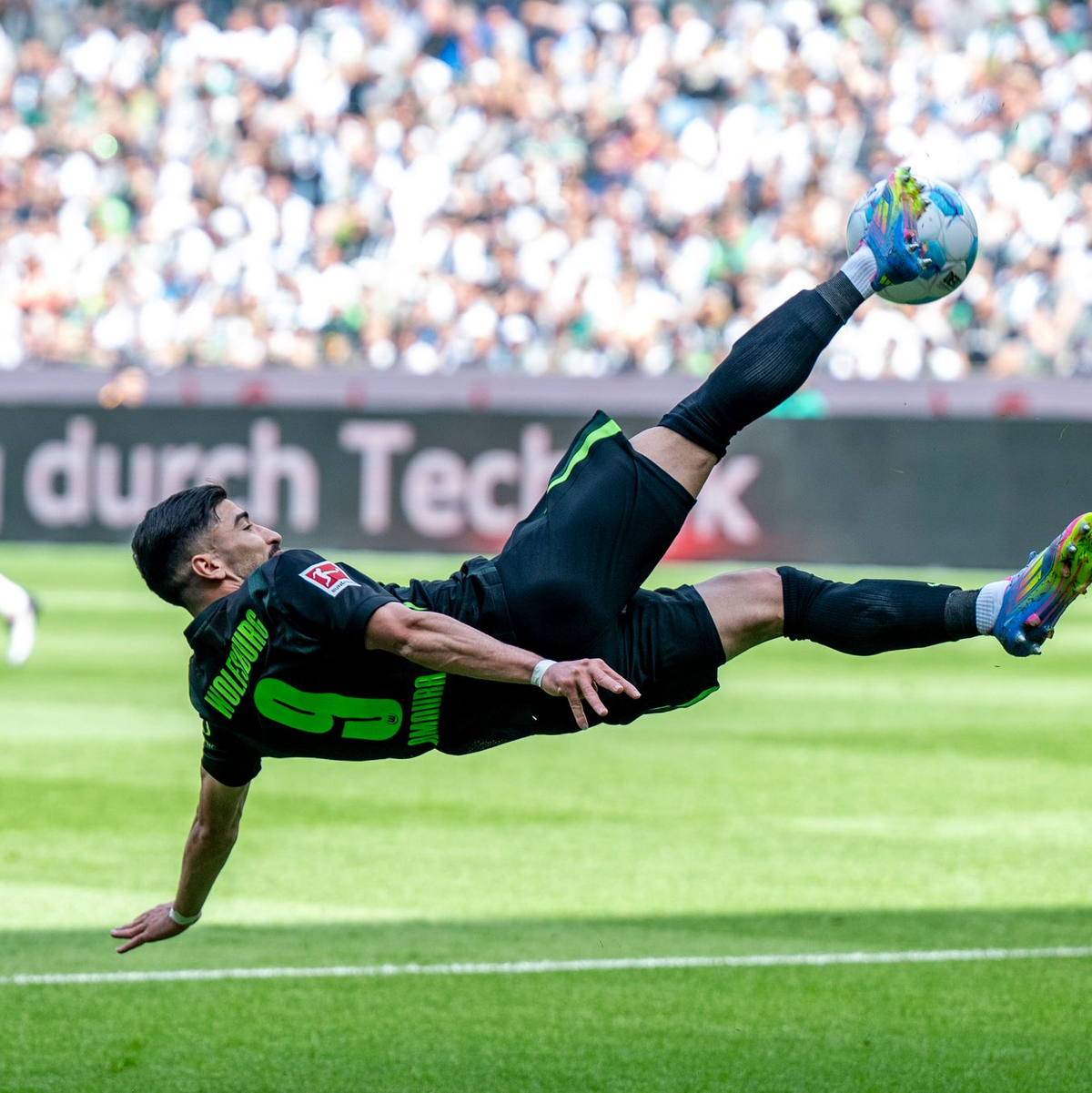 Grün gegen Weiß: Wolfsburgs Saël Kumbedi (r) im Zweikampf mit dem Gladbacher Luca Netz. - Foto: David Inderlied/dpa