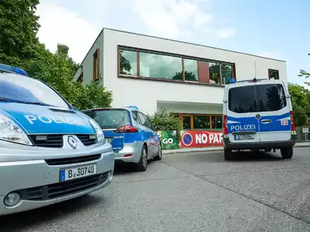 Polizisten stehen vor einer Schule im Berliner Bezirk Spandau, an der es einen Messerangriff gab. - Foto: Jörg Carstensen/dpa