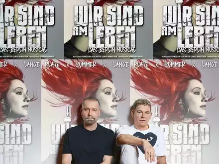 Ulf Leo Sommer und Peter Plate sitzen vor Plakaten ihres neuen Musical-Projekts. - Foto: Ferran Casanova/Theater des Westens/dpa