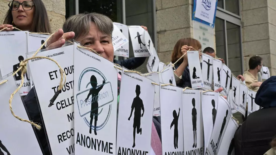 Demonstranten halten vor dem Gerichtsgebäude Schilder mit den Namen der Opfer. - Bild: Damien Meyer/AFP/dpa