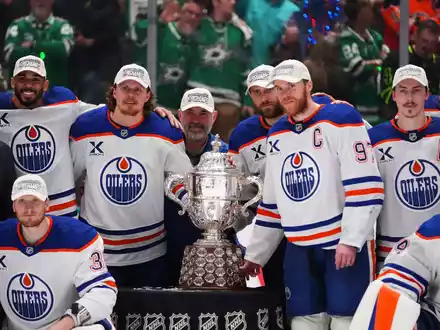 Leon Draisaitl posiert hinter Kapitän Connor McDavid mit dem Pokal für den Sieger der Western Conference. - Foto: Julio Cortez/AP/dpa