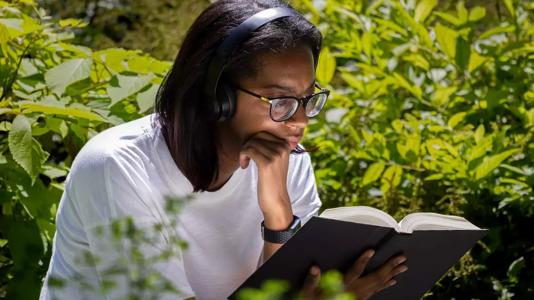 Junge Frau sitzt im Grünen und liest ein Buch.  - Bild: Pixabay@terski