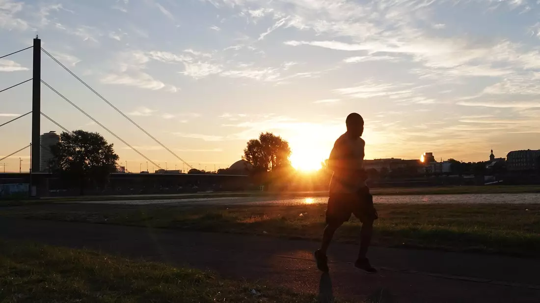 Ein Jogger in Düsseldorf: Auch Sport kann an extremen Hitzetagen gefährlich werden.  - Bild: Lukas Fortkord/dpa