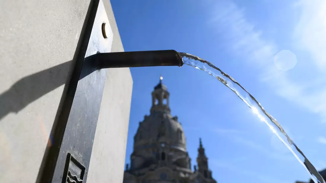 In Dresden spendet ein Trinkwasserbrunnen öffentlich zugängliche Abkühlung.  - Bild: Robert Michael/dpa