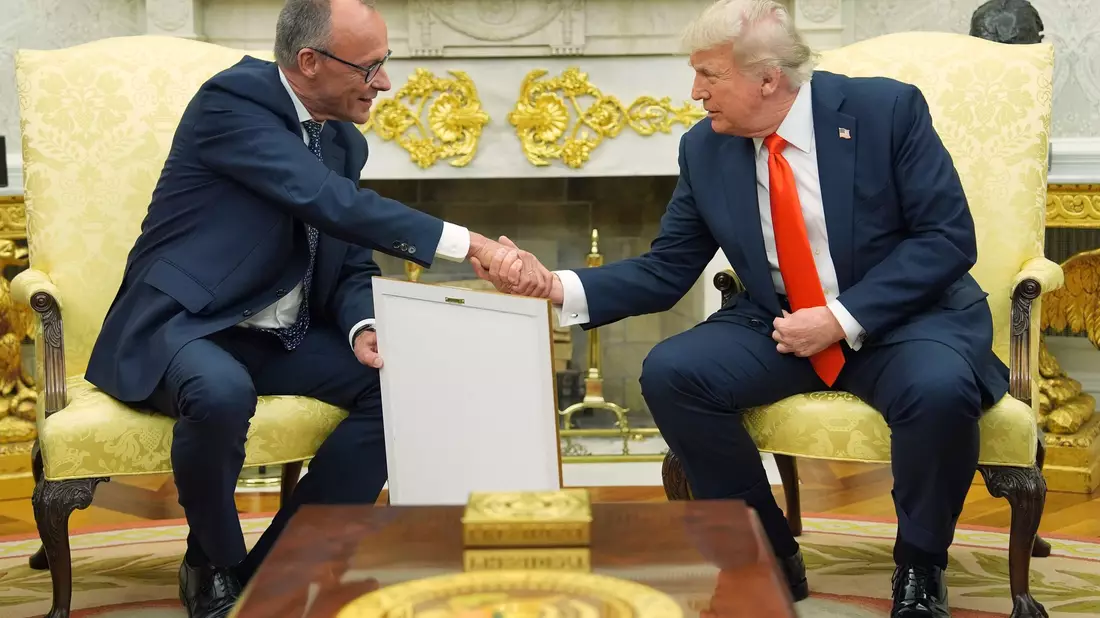 Merz übergab das Gastgeschenk im Oval Office.  - Bild: Evan Vucci/AP/dpa
