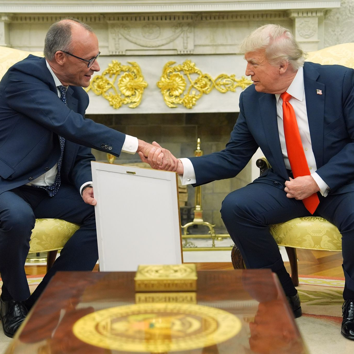 Merz übergab das Gastgeschenk im Oval Office.  - Foto: Evan Vucci/AP/dpa