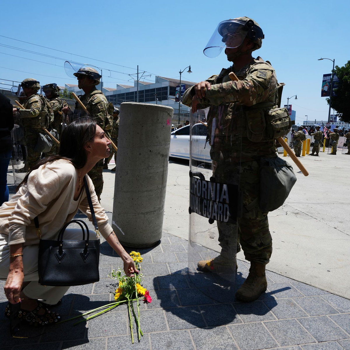 Eine Frau legt Blumen vor der Nationalgarde nieder.  - Foto: Damian Dovarganes/AP/dpa