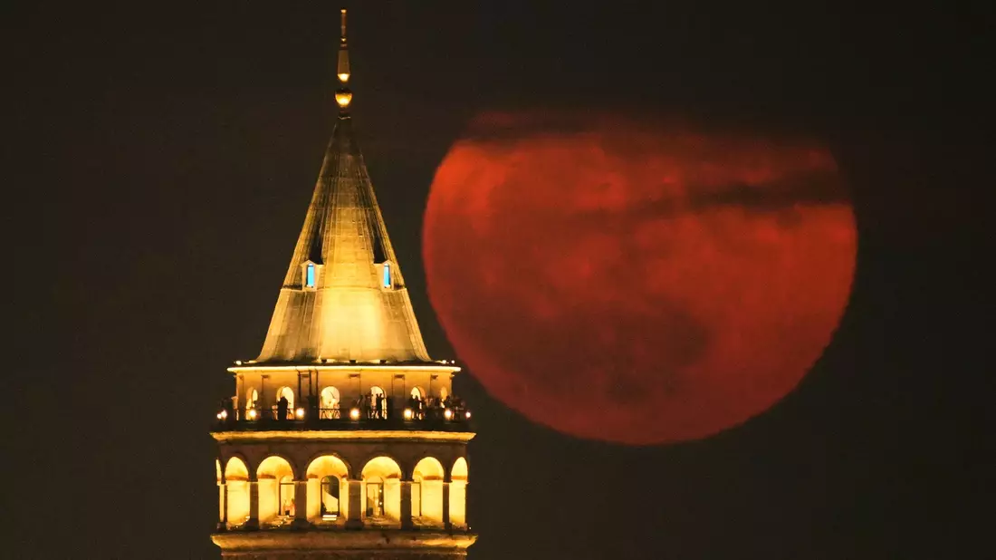Der Erdbeermond geht hinter dem Galata-Turm in Istanbul auf. - Bild: Emrah Gurel/AP/dpa