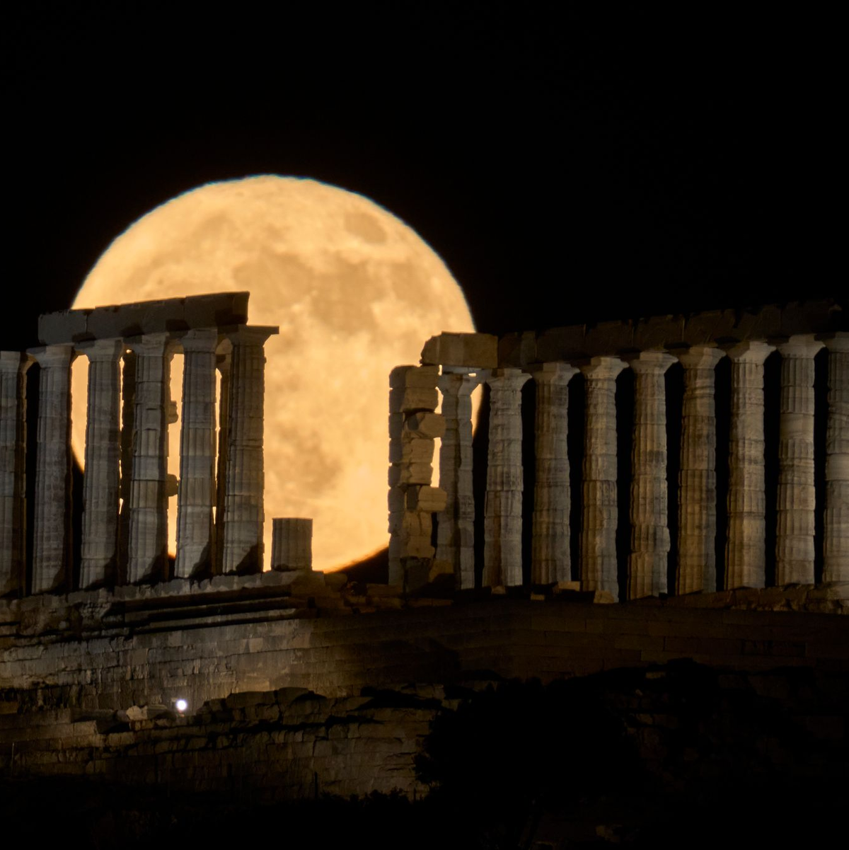 Der Erdbeermond geht in Griechenland hinter dem Poseidontempel am Kap Sounion auf. - Foto: Petros Giannakouris/AP/dpa