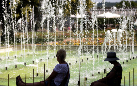 Zwei Frauen sitzen an einem Springbrunnen im egapark in Erfurt in Thüringen. - Foto: Michael Reichel/dpa