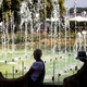 Zwei Frauen sitzen an einem Springbrunnen im egapark in Erfurt in Thüringen. - Foto: Michael Reichel/dpa
