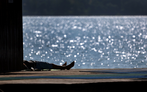 Ausflügler genießen auf dem Steg des Strandbades am Ammersee in Bayern den Sonnenschein. - Foto: Karl-Josef Hildenbrand/dpa