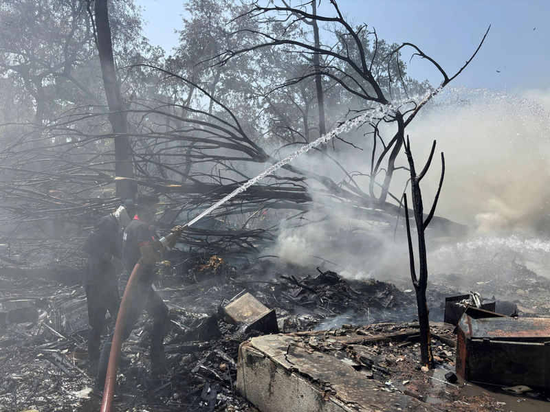 Feuerwehrleute sind im Einsatz. - Foto: Ajit Solanki/AP/dpa