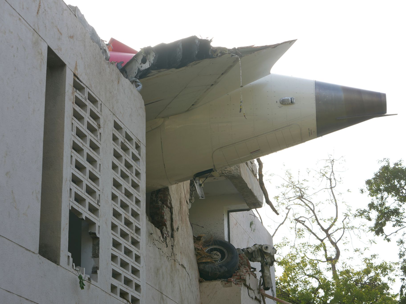 Trümmer der Boeing 787-8 Dreamliner ragen aus einem Gebäude.  - Foto: Ajit Solanki/AP/dpa