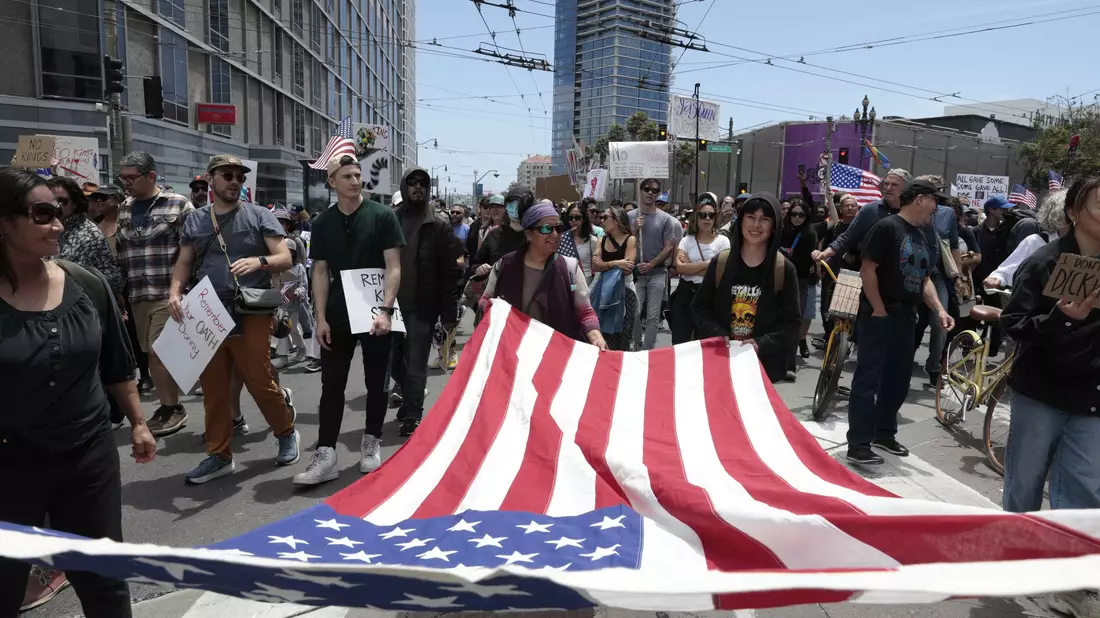 Demonstranten in San Francisco marschierten mit einer großen US-Flagge. - Bild: Yalonda M. James/San Francisco Chronicle/AP/dpa
