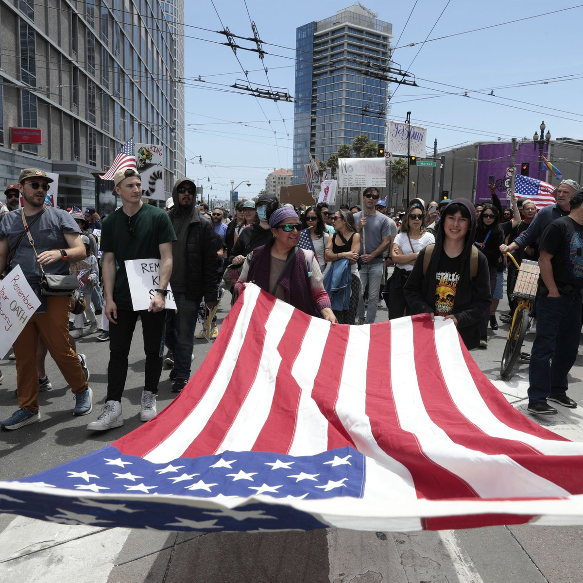 Demonstranten in San Francisco marschierten mit einer großen US-Flagge. - Foto: Yalonda M. James/San Francisco Chronicle/AP/dpa