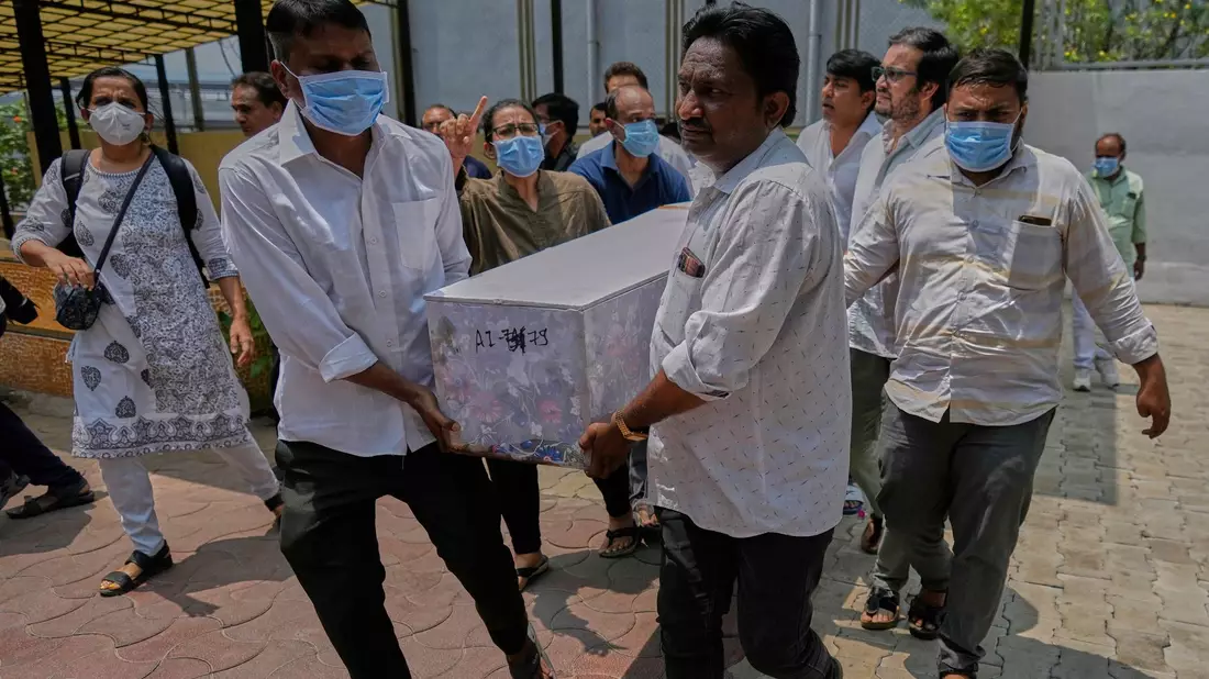 Arbeiter sind an der Absturzstelle im Einsatz. - Bild: Rafiq Maqbool/AP/dpa