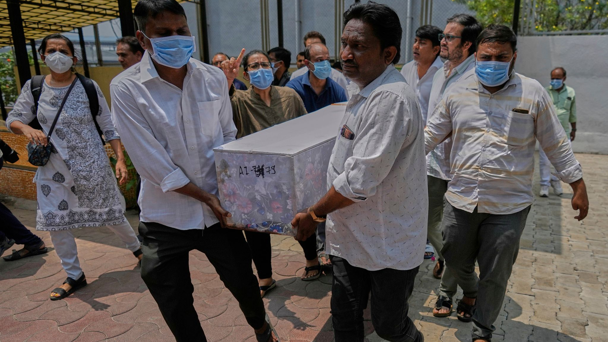 Arbeiter sind an der Absturzstelle im Einsatz. - Foto: Rafiq Maqbool/AP/dpa