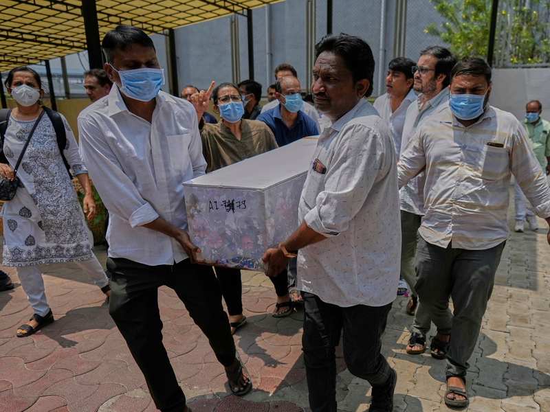 Arbeiter sind an der Absturzstelle im Einsatz. - Foto: Rafiq Maqbool/AP/dpa