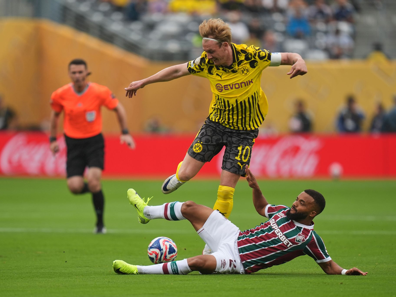 BVB-Keeper Gregor Kobel im Zusammenstoß mit Fluminenses Everaldo.  - Foto: Seth Wenig/AP/dpa