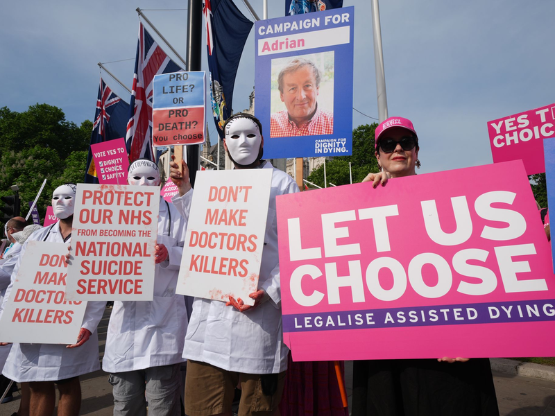 Befürworter und Gegner einer Regelung, die Sterbehilfe ermöglicht, vor dem Parlament in London. - Foto: Lucy North/PA Wire/dpa