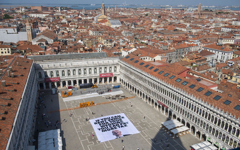 Mit einem Plakat auf dem Markusplatz fordern Greenpeace-Aktivisten, Bezos höher zu besteuern. - Foto: Greenpeace/Greenpeace/AP/dpa Mit einem Plakat auf dem Markusplatz fordern Greenpeace-Aktivisten, Bezos höher zu besteuern. - Foto: Greenpeace/Greenpeace/AP/dpa