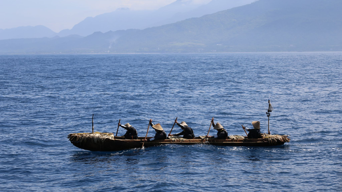 Ein Mann fällt einen Baum für den Nachbau eines steinzeitlichen Kanus. - Foto: Yousuke Kaifu/dpa