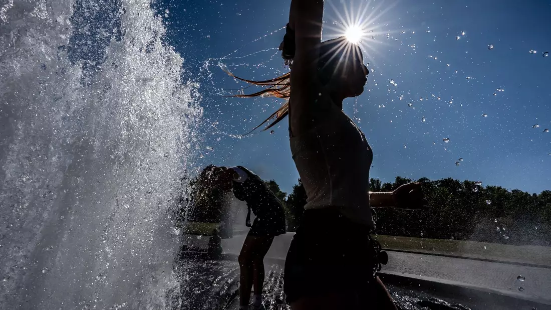 Temperaturen von annähernd 40 Grad in der Hauptstadt - diese Touristen nutzen einen Brunnen zur Abkühlung. - Bild: Michael Kappeler/dpa