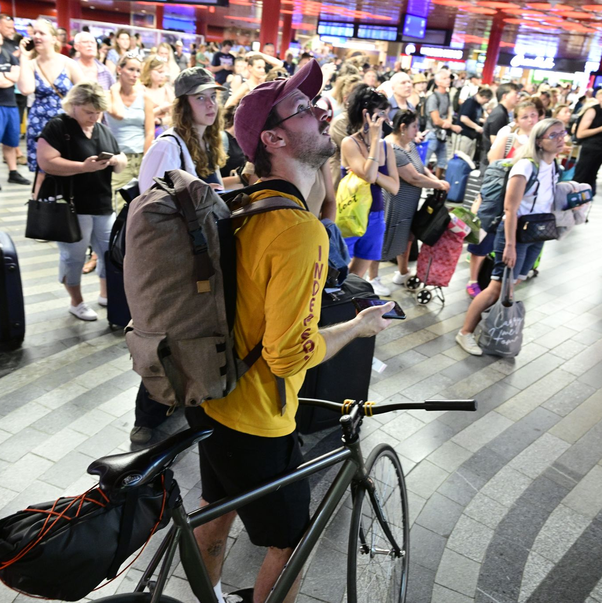 Passagiere sitzen in der Halle des Prager Hauptbahnhofs während eines Stromausfalls.  - Foto: Vondrouš Roman/CTK/dpa