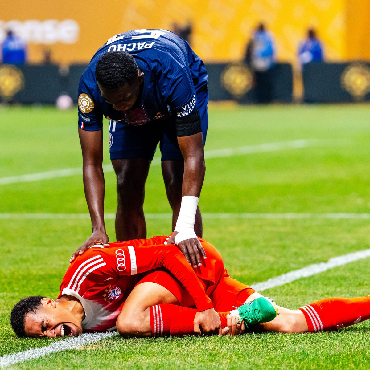 Jamal Musiala liegt mit starken Schmerzen verletzt am Boden. PSG-Profi William Pacho kümmert sich um ihn. - Foto: Malachi Gabriel/ZUMA Press Wire/dpa