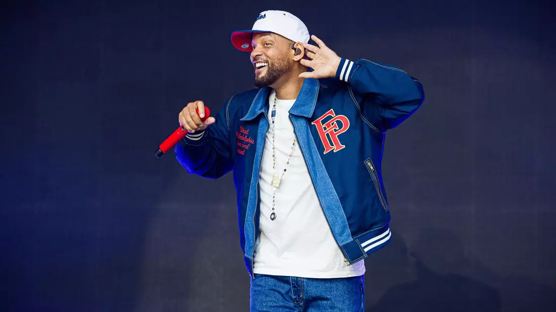 Mit Tänzerinnen und Liveband sorgt Will Smith in Wolfsburg für Stimmung. - Bild: Moritz Frankenberg/dpa
