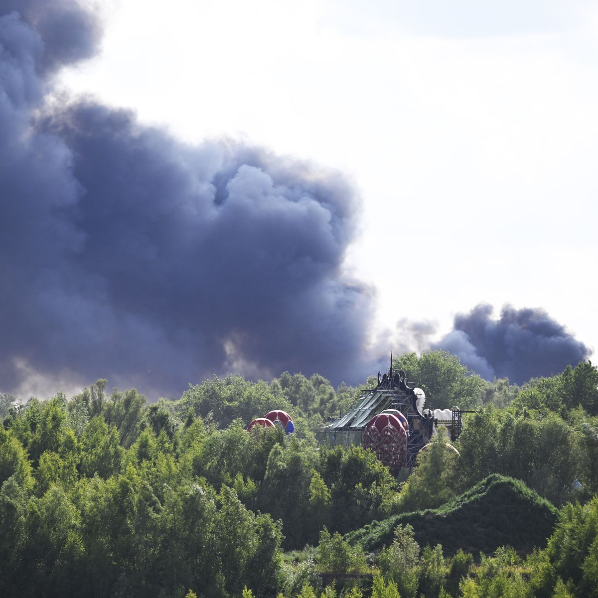 Vom Gelände des Tomorrowland-Festivals steigt am Mittwoch dunkler Rauch auf: Die Größe der Rauchwolke lässt das Ausmaß des Brandes erahnen. - Foto: Tom Goyvaerts/Belga/dpa