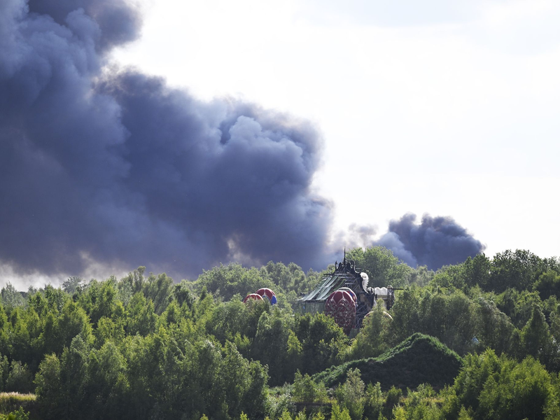 Vom Gelände des Tomorrowland-Festivals steigt am Mittwoch dunkler Rauch auf: Die Größe der Rauchwolke lässt das Ausmaß des Brandes erahnen. - Foto: Tom Goyvaerts/Belga/dpa
