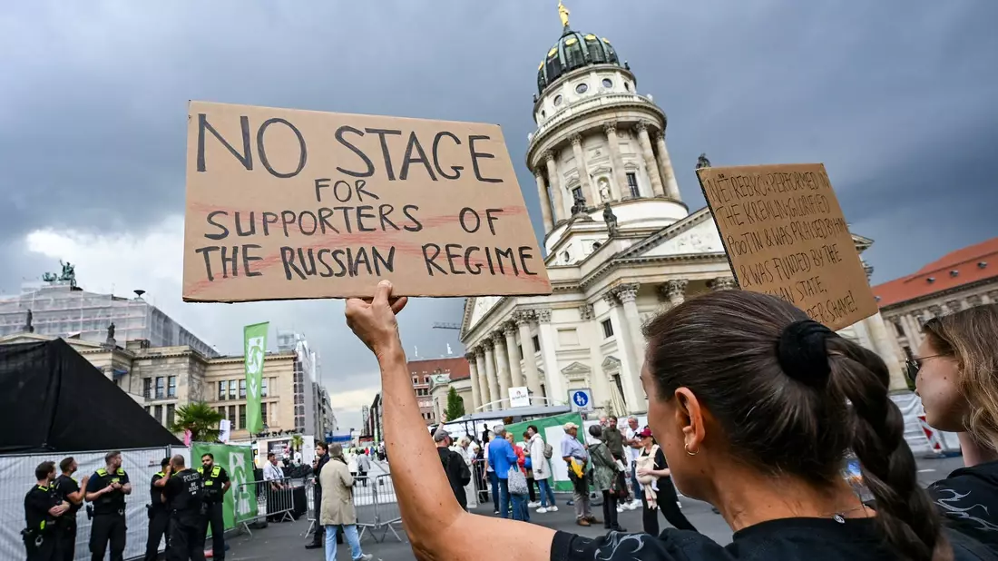 Demonstranten am Gendarmenmarkt protestierten gegen den Auftritt der Starsopranistin Anna Netrebko beim Musikfestival «Classic Open Air».  - Bild: Jens Kalaene/dpa