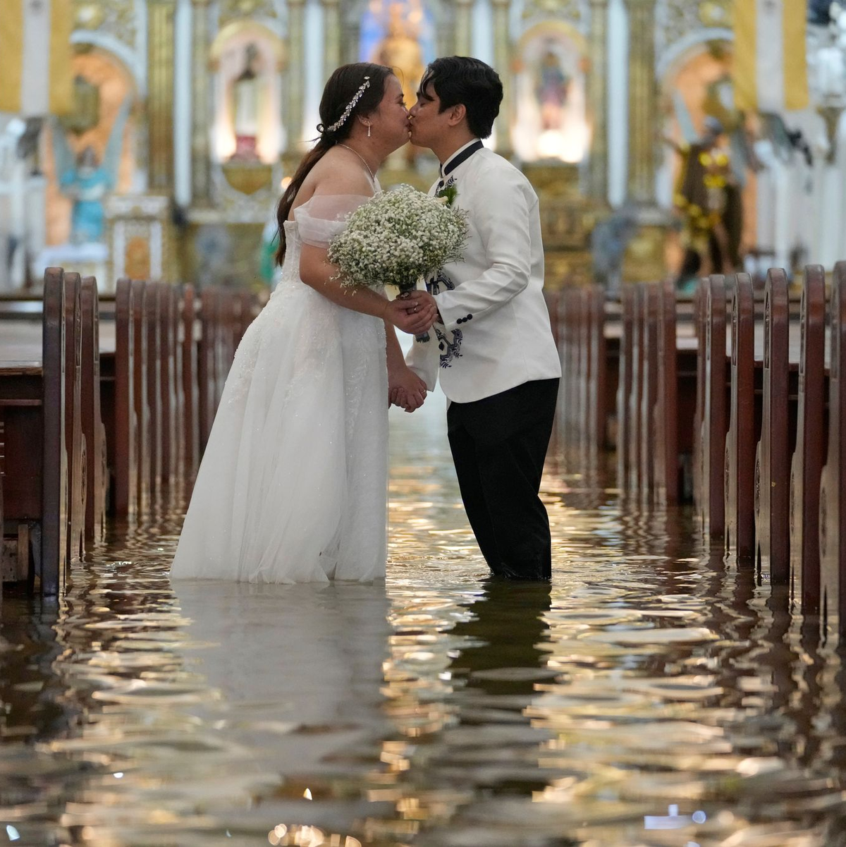 Die Braut ließ sich von den Wassermassen nicht beirren. - Foto: Aaron Favila/AP/dpa