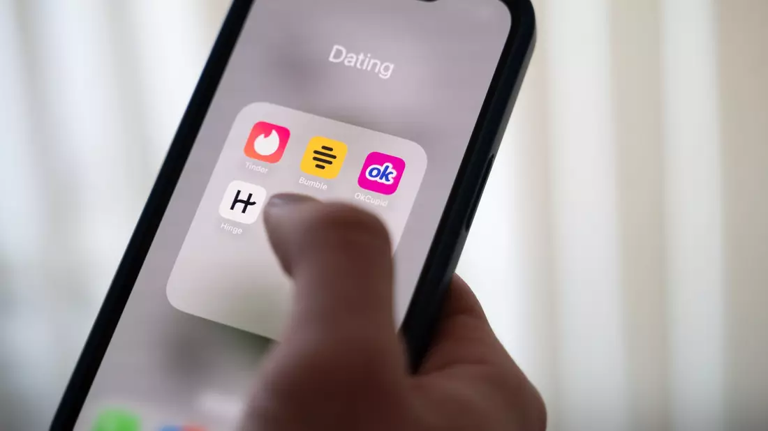 Eine Frau hält ein Smartphone, auf dem Dating-Apps angezeigt werden. (Symbolbild) - Bild: Alicia Windzio/dpa