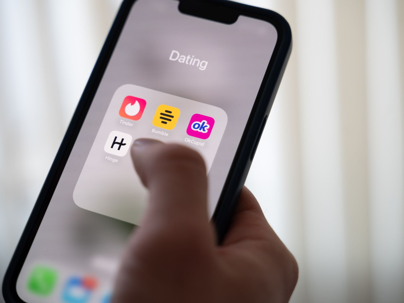 Eine Frau hält ein Smartphone, auf dem Dating-Apps angezeigt werden. (Symbolbild) - Foto: Alicia Windzio/dpa
