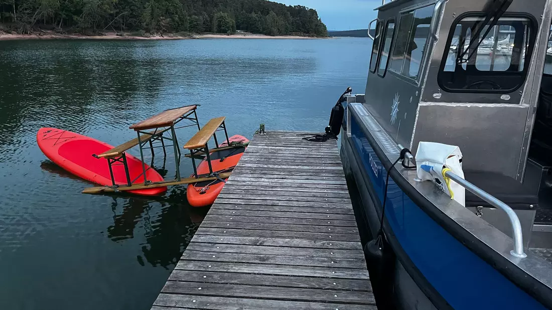 Das Trio war auf einer Konstruktion aus Surfbrettern und einer Bierbank auf dem Brombachsee unterwegs. Bild: Polizei Mittelfranken - Bild: -/Polizei Mittelfranken/dpa