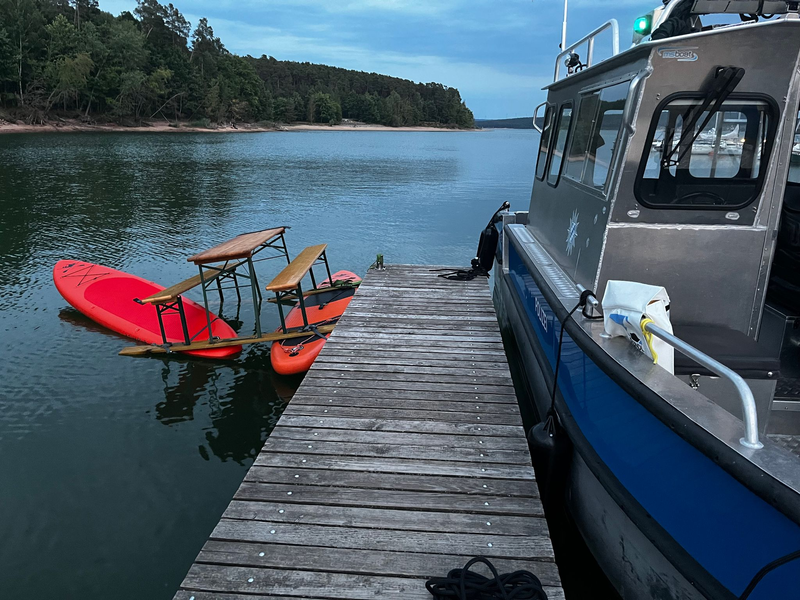 Das Trio war auf einer Konstruktion aus Surfbrettern und einer Bierbank auf dem Brombachsee unterwegs. Bild: Polizei Mittelfranken - Foto: -/Polizei Mittelfranken/dpa