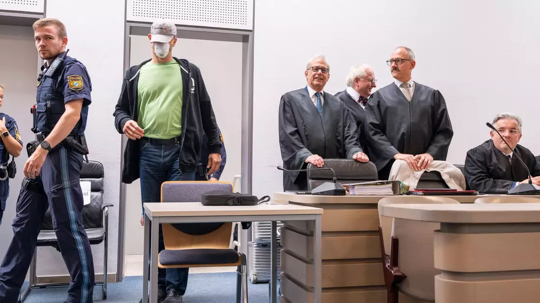 Angeklagte nehmen vor der Urteilsverkündung auf der Anklagebank Platz. - Bild: Peter Kneffel/dpa