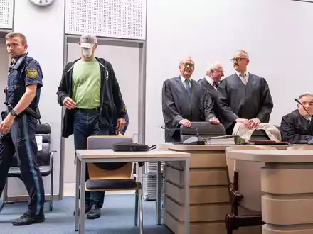Angeklagte nehmen vor der Urteilsverkündung auf der Anklagebank Platz. - Foto: Peter Kneffel/dpa