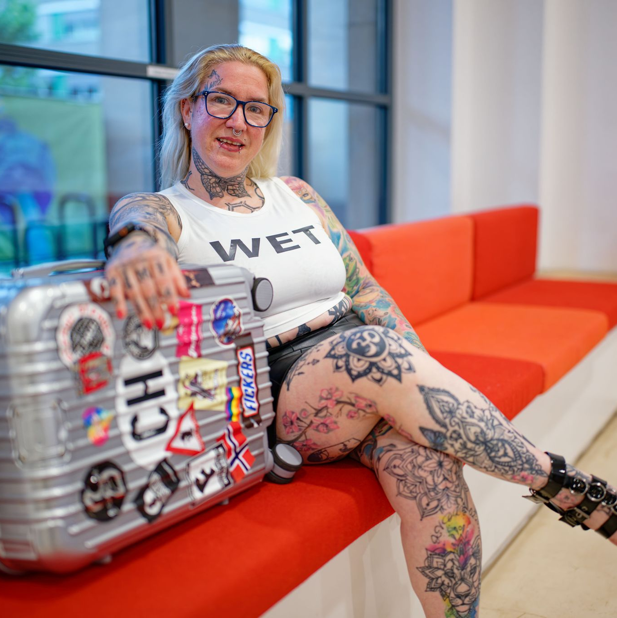 «Mimi» sitzt kurz vor der Abreise ins französische Cap d’Agde mit ihrem Koffer im Mannheimer Rathaus. - Foto: Uwe Anspach/dpa