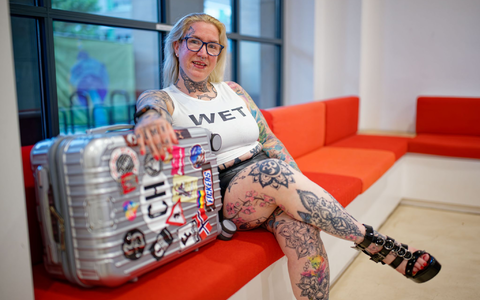 «Mimi» sitzt kurz vor der Abreise ins französische Cap d’Agde mit ihrem Koffer im Mannheimer Rathaus. - Foto: Uwe Anspach/dpa