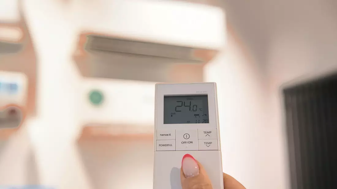  24 Grad: Mithilfe einer Fernbedienung wird die Temperatur einer Klimaanlage im Showroom einer Berliner Firma reguliert. - Bild: Paul Zinken/dpa