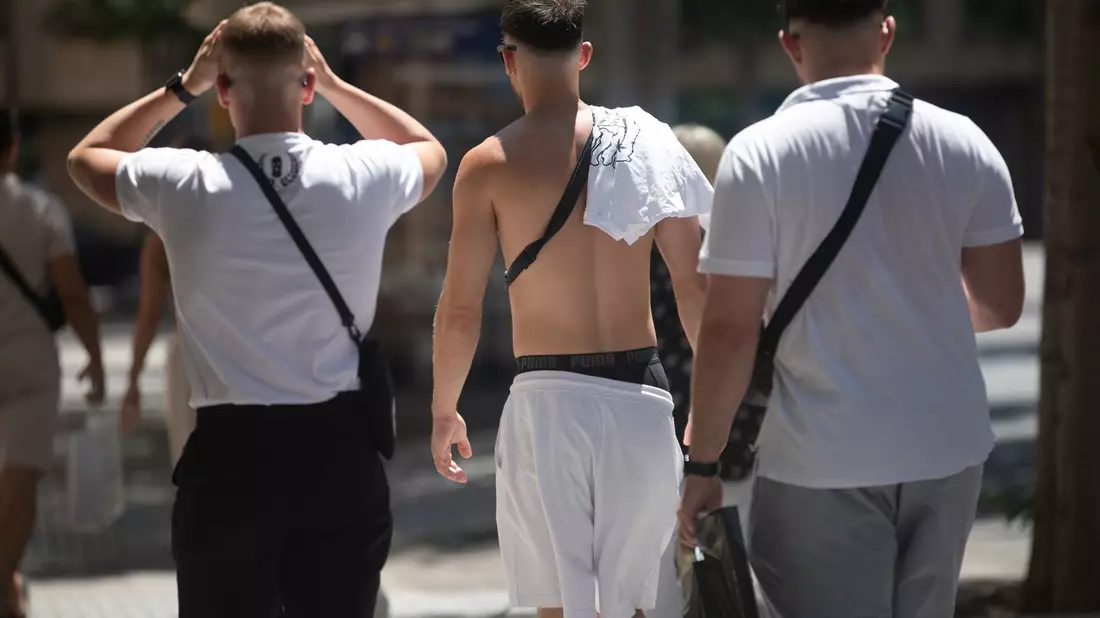 Junge Männer gehen mit nacktem Oberkörper auf Mallorca spazieren. (Archivbild) - Bild: Clara Margais/dpa