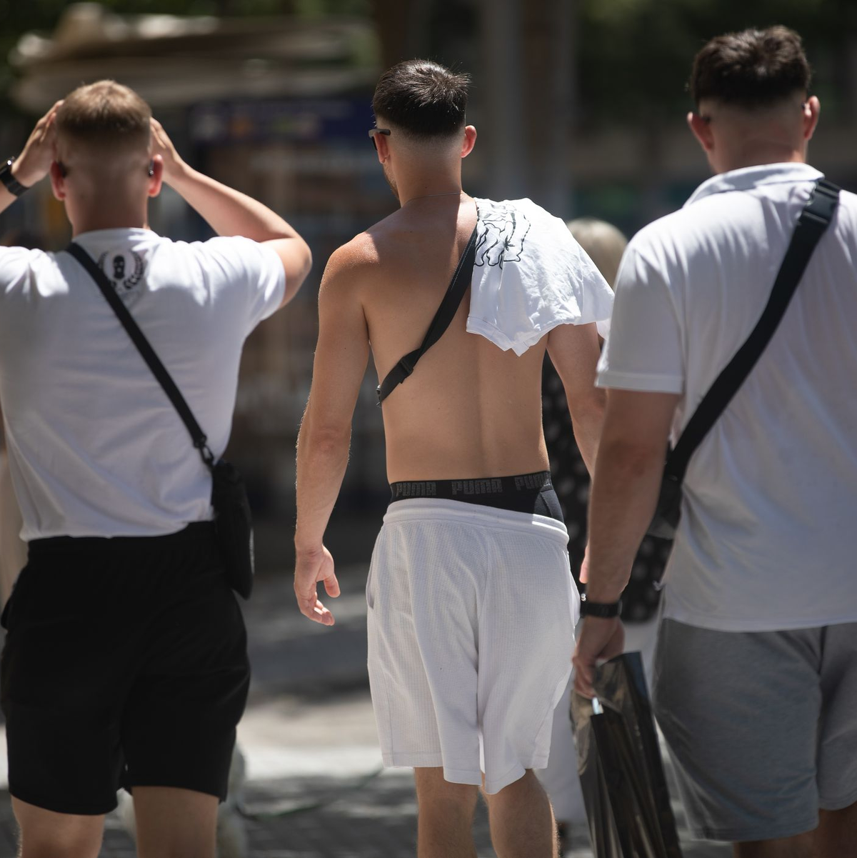 Junge Männer gehen mit nacktem Oberkörper auf Mallorca spazieren. (Archivbild) - Foto: Clara Margais/dpa