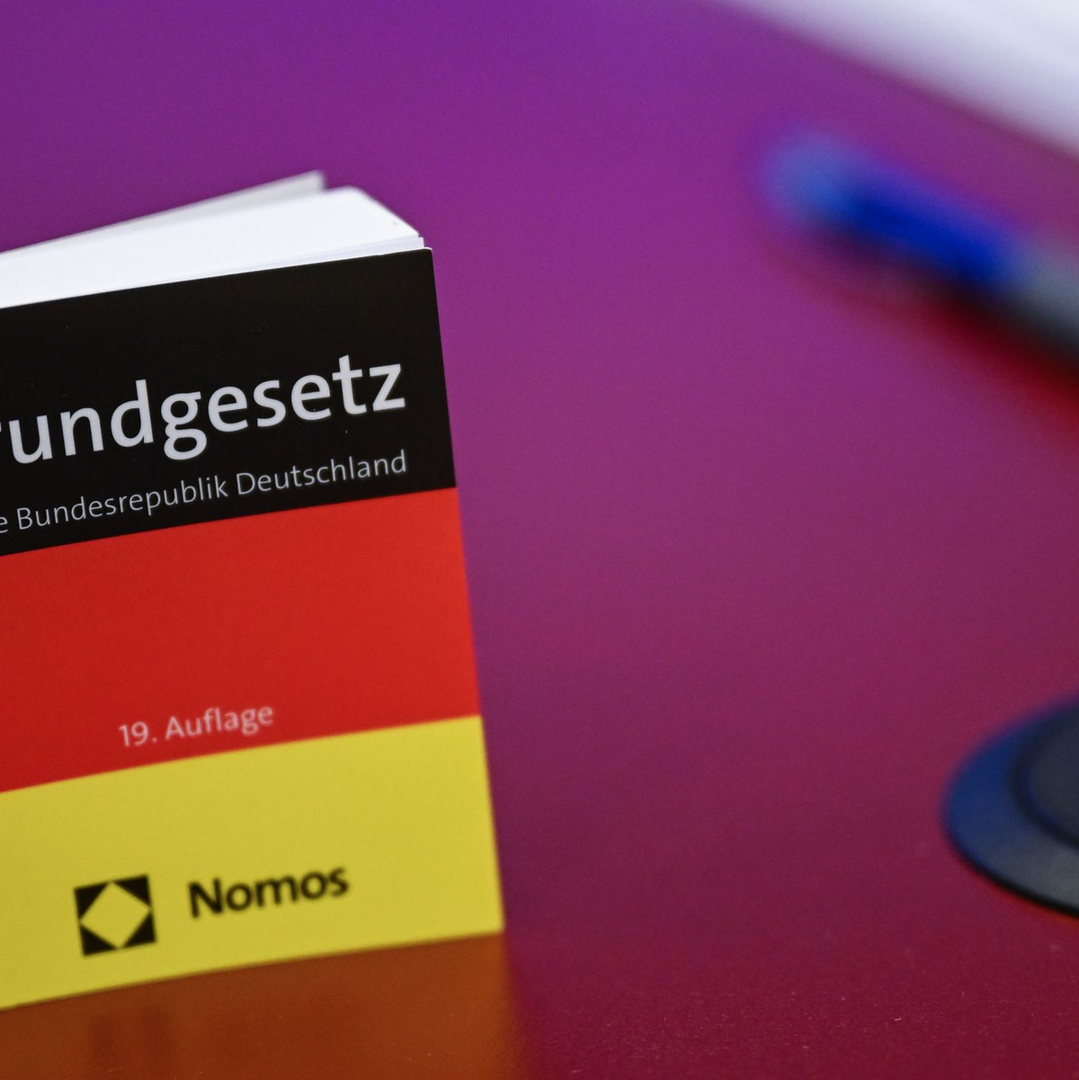 Das Grundgesetz in Miniatur-Ausgabe steht bei der Pressekonferenz zur AfD auf einem Tisch.  - Foto: Britta Pedersen/dpa