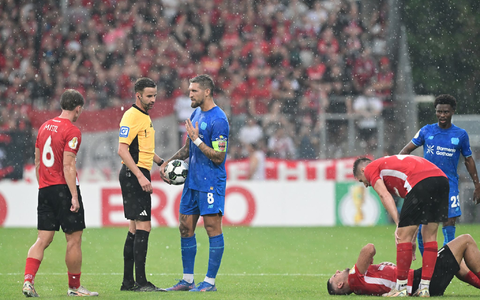Schiedsrichter Michael Bacher (2.v.l.) muss das Spiel in Großaspach unterbrechen - Foto: Bernd Weißbrod/dpa Schiedsrichter Michael Bacher (2.v.l.) muss das Spiel in Großaspach unterbrechen - Foto: Bernd Weißbrod/dpa