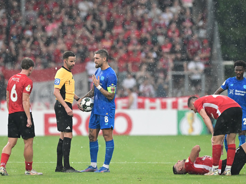Schiedsrichter Michael Bacher (2.v.l.) muss das Spiel in Großaspach unterbrechen - Foto: Bernd Weißbrod/dpa