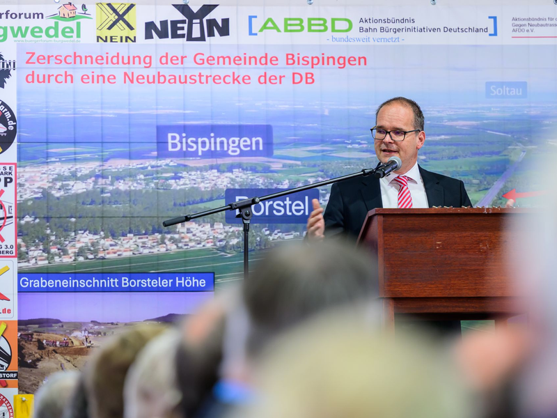 Peter Dörsam (Bündnis 90/Die Grünen), Sprecher des Projektbeirats Alpha-E und Bürgermeister der Samtgemeinde Tostedt, spricht beim «Heidegipfel» zu dem die Bürgerinitiativen Pro-Alpha-E und der Projektbeirat Alpha-E eingeladen haben. Beim «Heidegipfel» geht es um verschiedene Perspektiven zum Aus- oder Neubau der Schienenstrecke Hamburg-Hannover. - Foto: Philipp Schulze/dpa